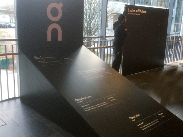 kleiner Messestand mit Regalen, Prsentern und schrgem Podest